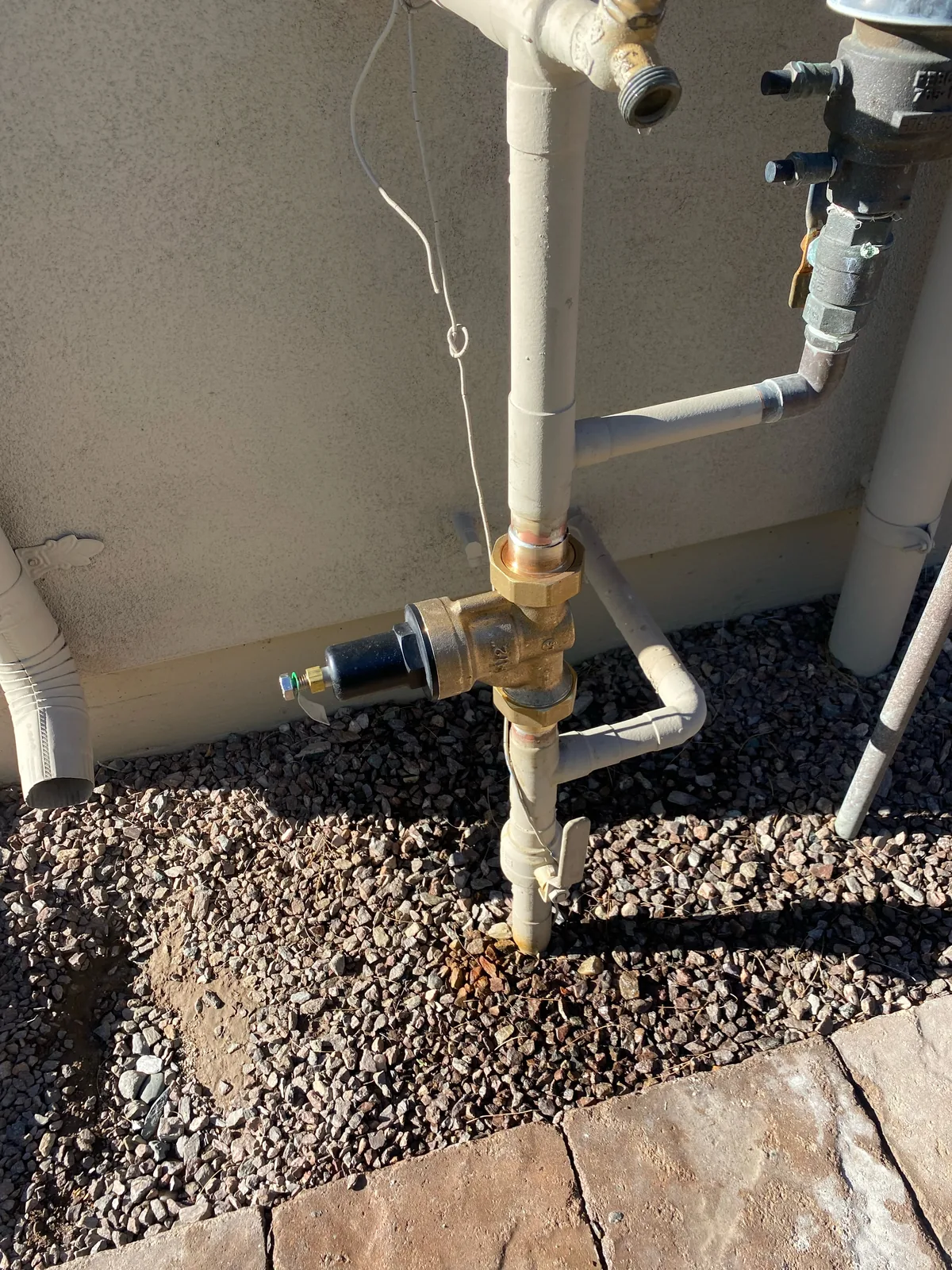 New brass pressure-reducing valve (PRV) installed on the main water line outside a home in Surprise, AZ